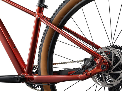 Close-up of a red bicycle frame with chain and gears on a white background