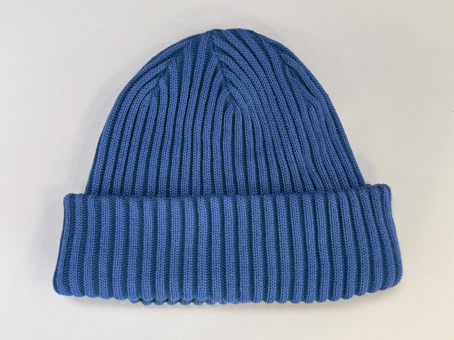 Blue knit beanie on a light gray background