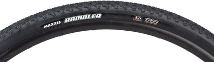 Close-up of a Maxxis bicycle tire with tread pattern and branding on a white background