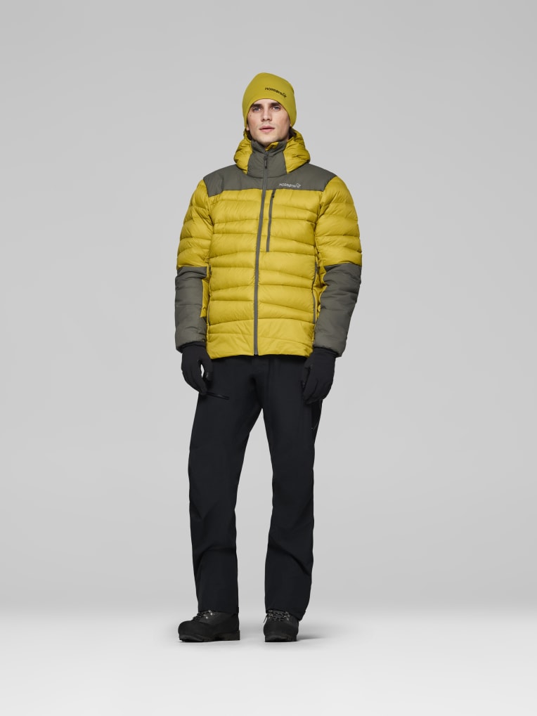 Person wearing a yellow and gray puffer jacket on a white background