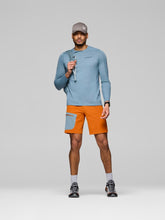 Load image into Gallery viewer, Man wearing a blue long-sleeve shirt, orange shorts, and a gray cap on a light gray background
