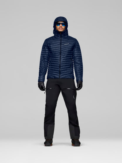 Person wearing a dark blue jacket and black pants on a gray background