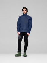Load image into Gallery viewer, Person wearing a blue jacket and black pants with green boots on a gray background
