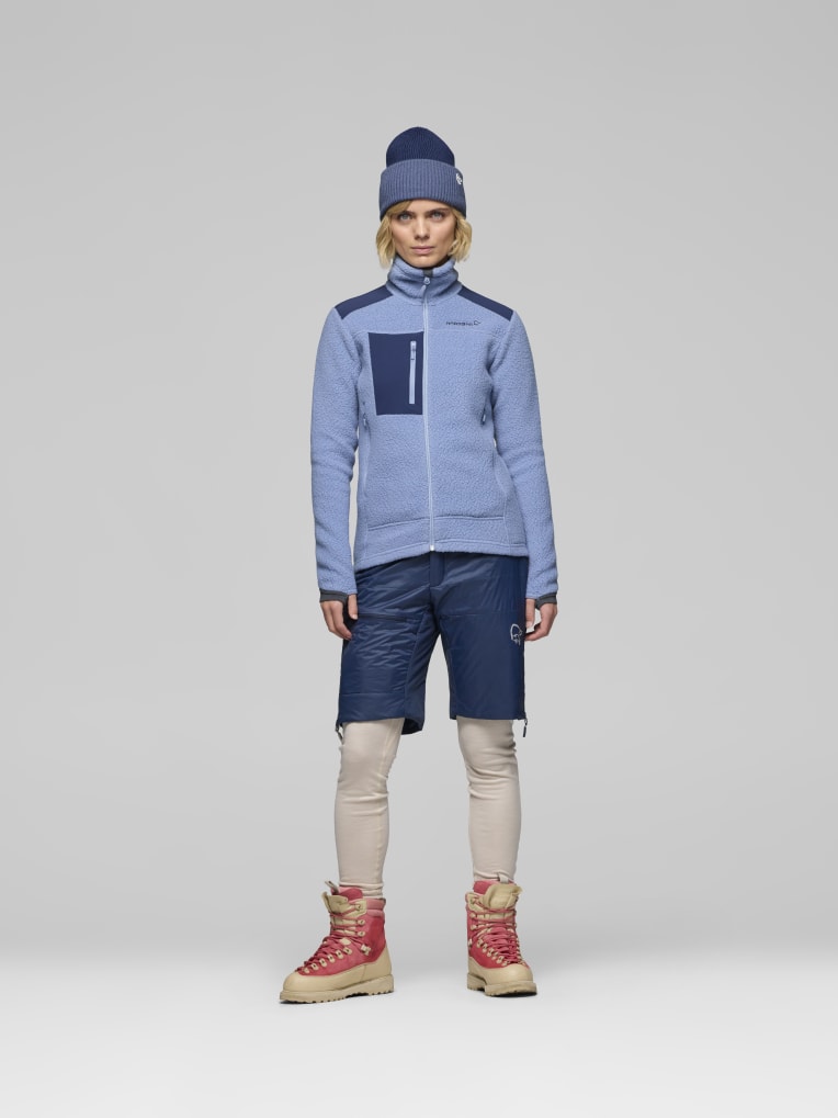 Person wearing a blue jacket, navy pants, and red boots on a white background