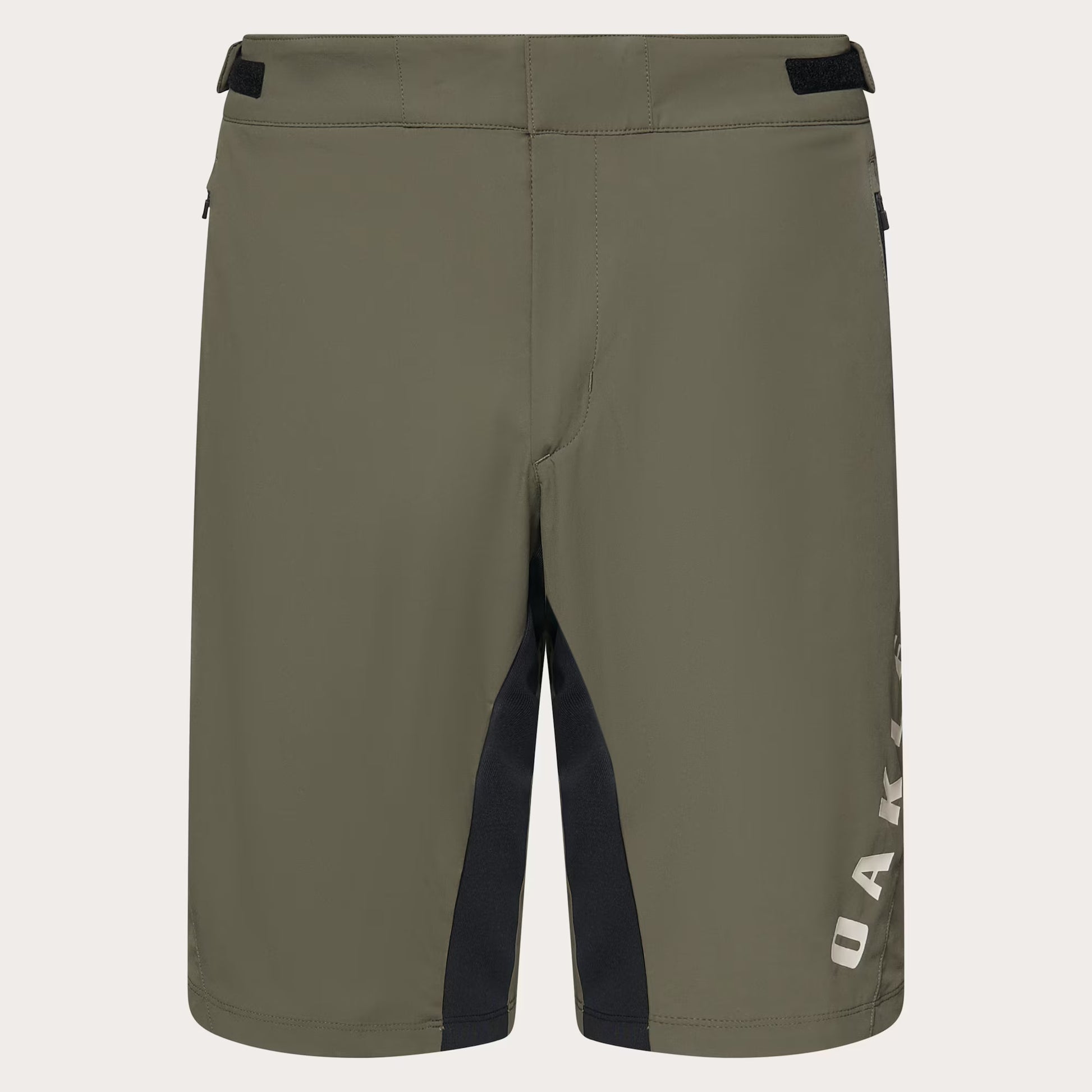 Olive green Oakley shorts with black side paneling and a white vertical Oakley logo on the lower right leg, shown against a light off-white background.