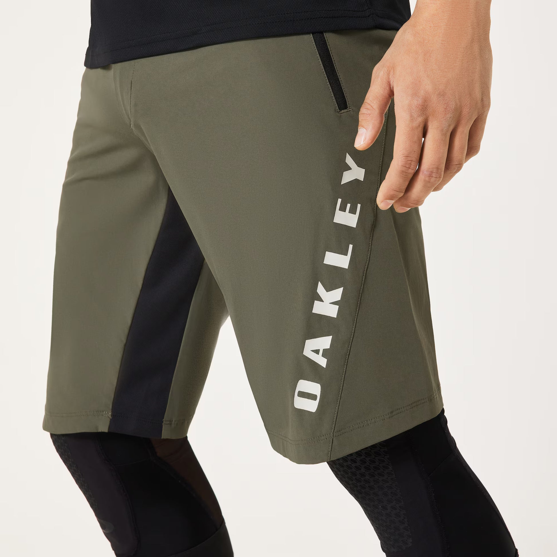 Green athletic shorts with Oakley branding on a white background