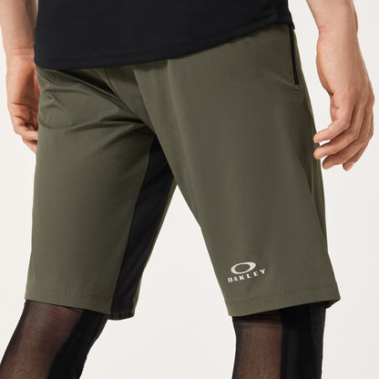 Green shorts with Oakley logo worn by a person on a light gray background