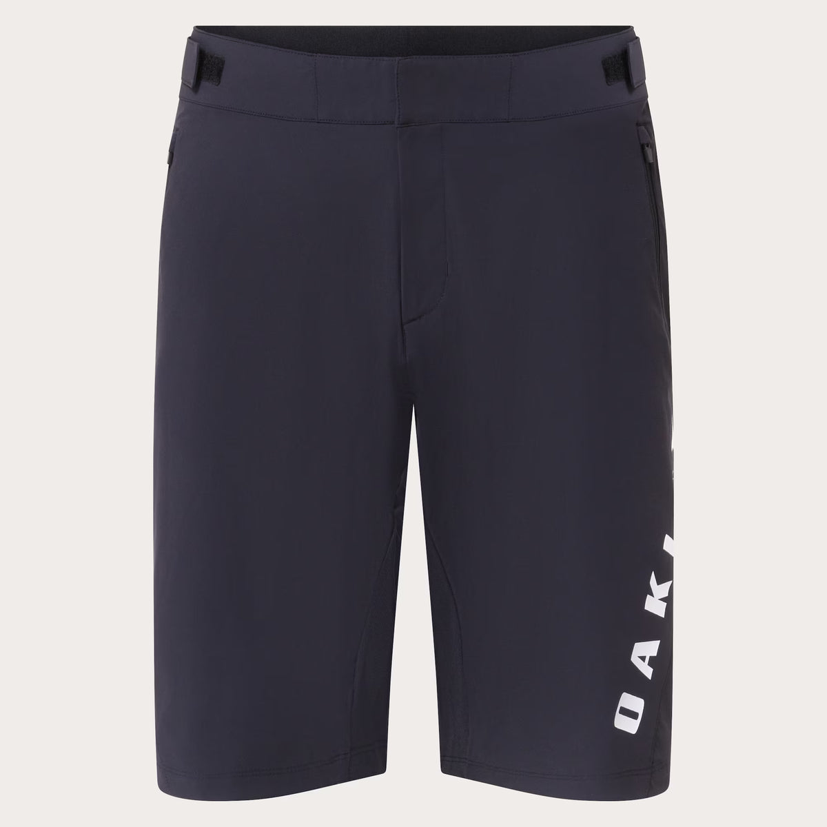 Dark navy blue athletic shorts with a vertical white 'OAKLEY' logo printed on the lower left leg, shown against a light off-white background.