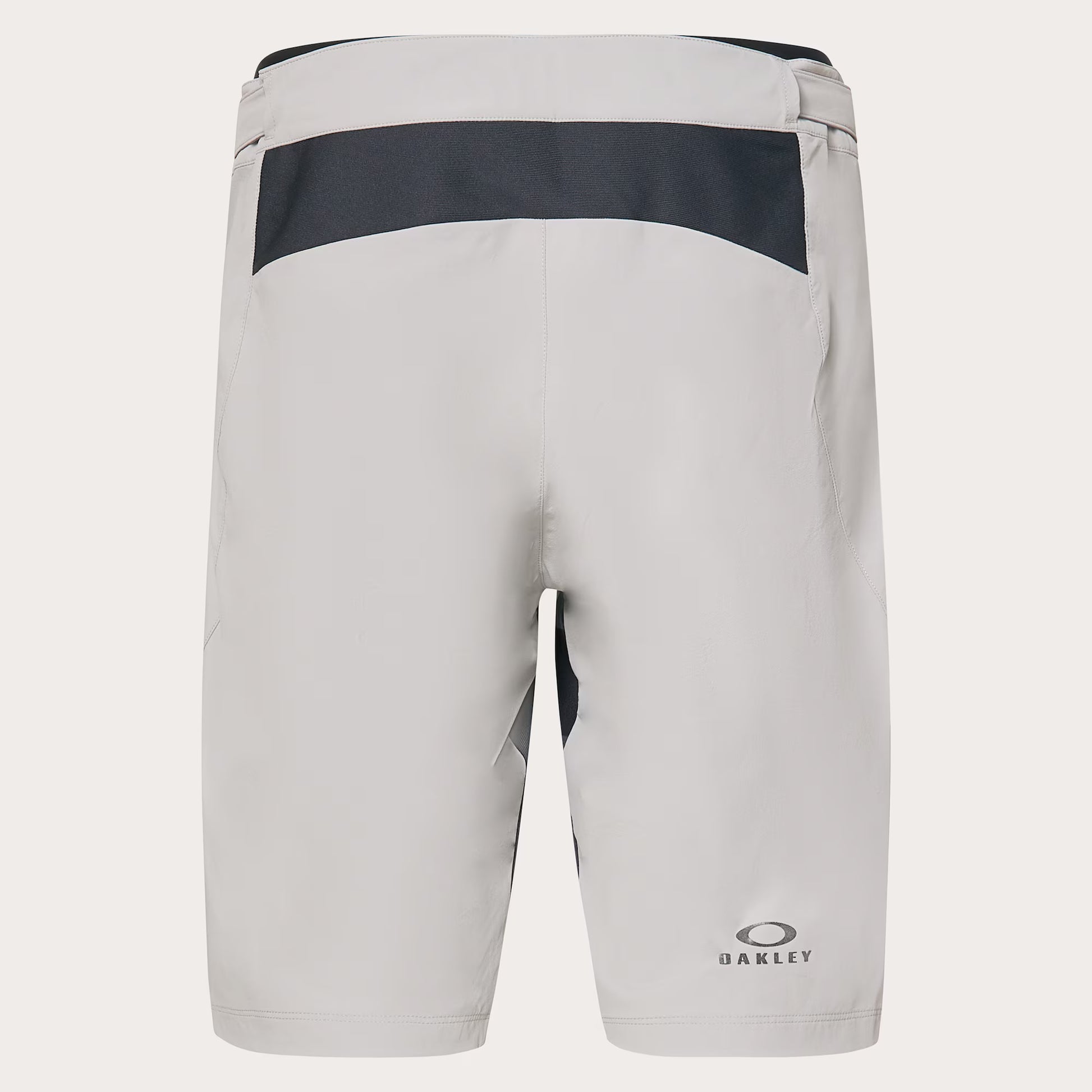 Oakley athletic shorts in light gray with a dark gray horizontal panel across the upper back, shown from the rear on a light gray background.