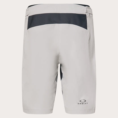 Oakley athletic shorts in light gray with a dark gray horizontal panel across the upper back, shown from the rear on a light gray background.