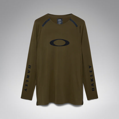 An olive brown long-sleeve athletic shirt by Oakley, featuring a large black Oakley logo on the chest, black vertical branding on both sleeves, and black shoulder detailing, shown against a neutral gray background.