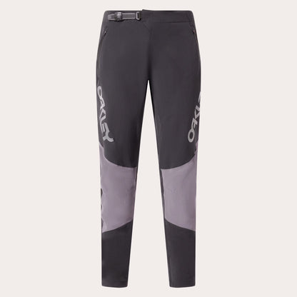 A pair of dark gray and light gray colorblock mountain biking pants with white OAKLEY branding printed vertically on the sides, shown against a light gray background.