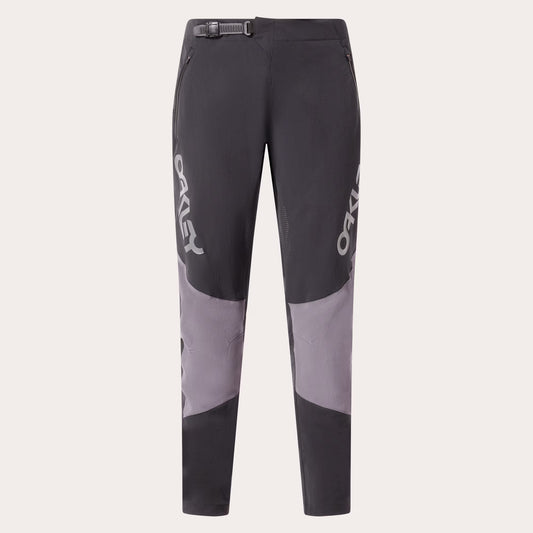 A pair of dark gray and light gray colorblock mountain biking pants with white OAKLEY branding printed vertically on the sides, shown against a light gray background.