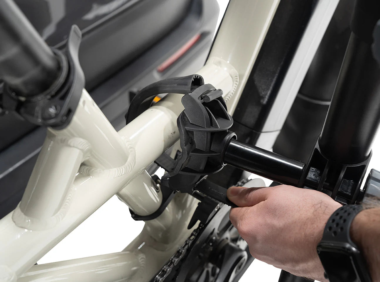 Person attaching a bike to a car using a bike rack.