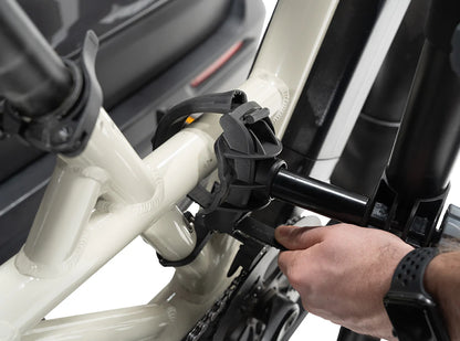 Person attaching a bike to a car using a bike rack.