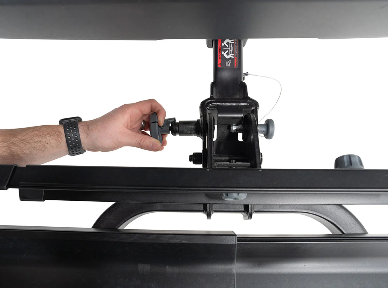 Hand adjusting a car roof rack on a white background
