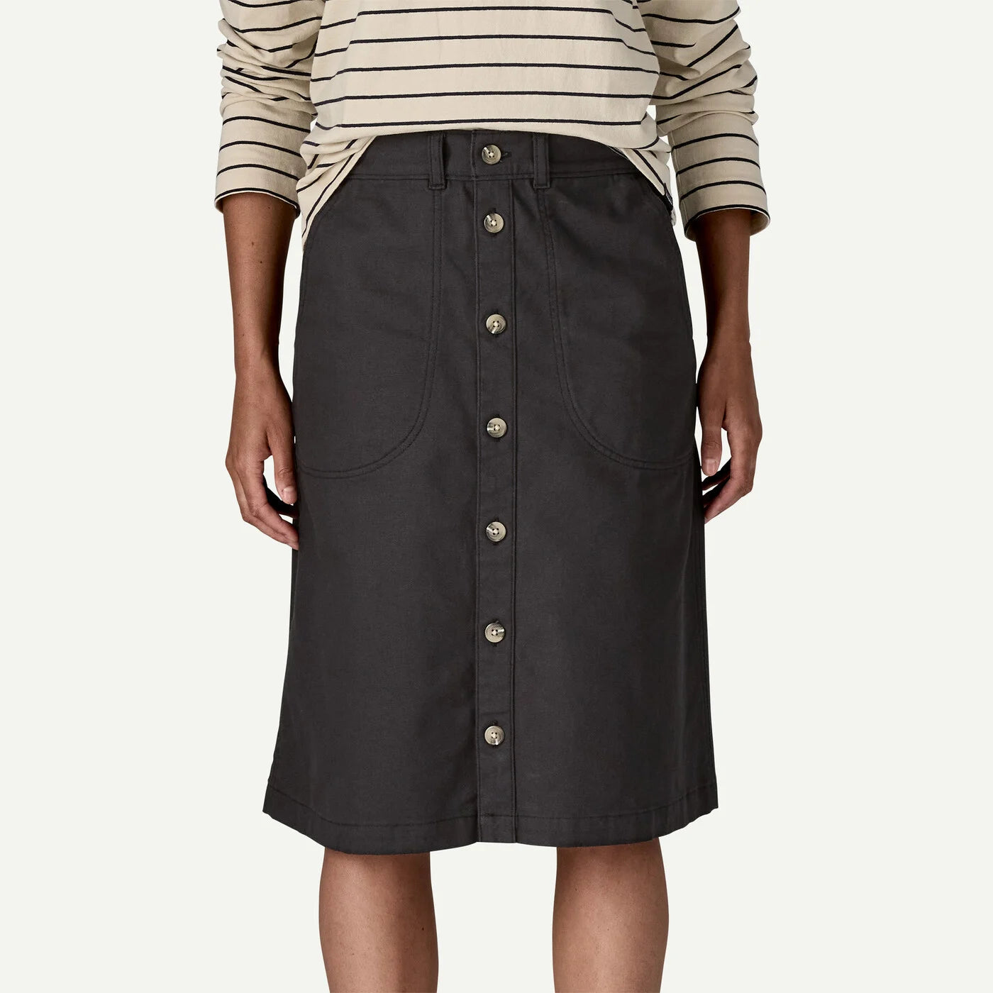 Black button-up skirt worn by a person on a white background