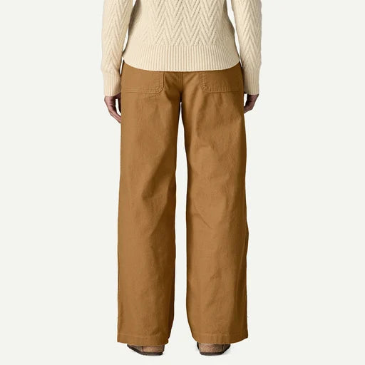 Person wearing a beige sweater and brown pants on a white background