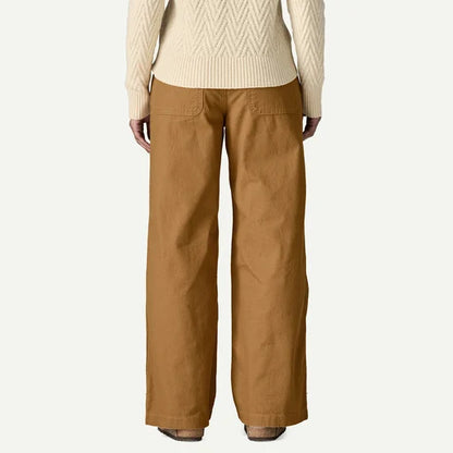 Person wearing a beige sweater and brown pants on a white background
