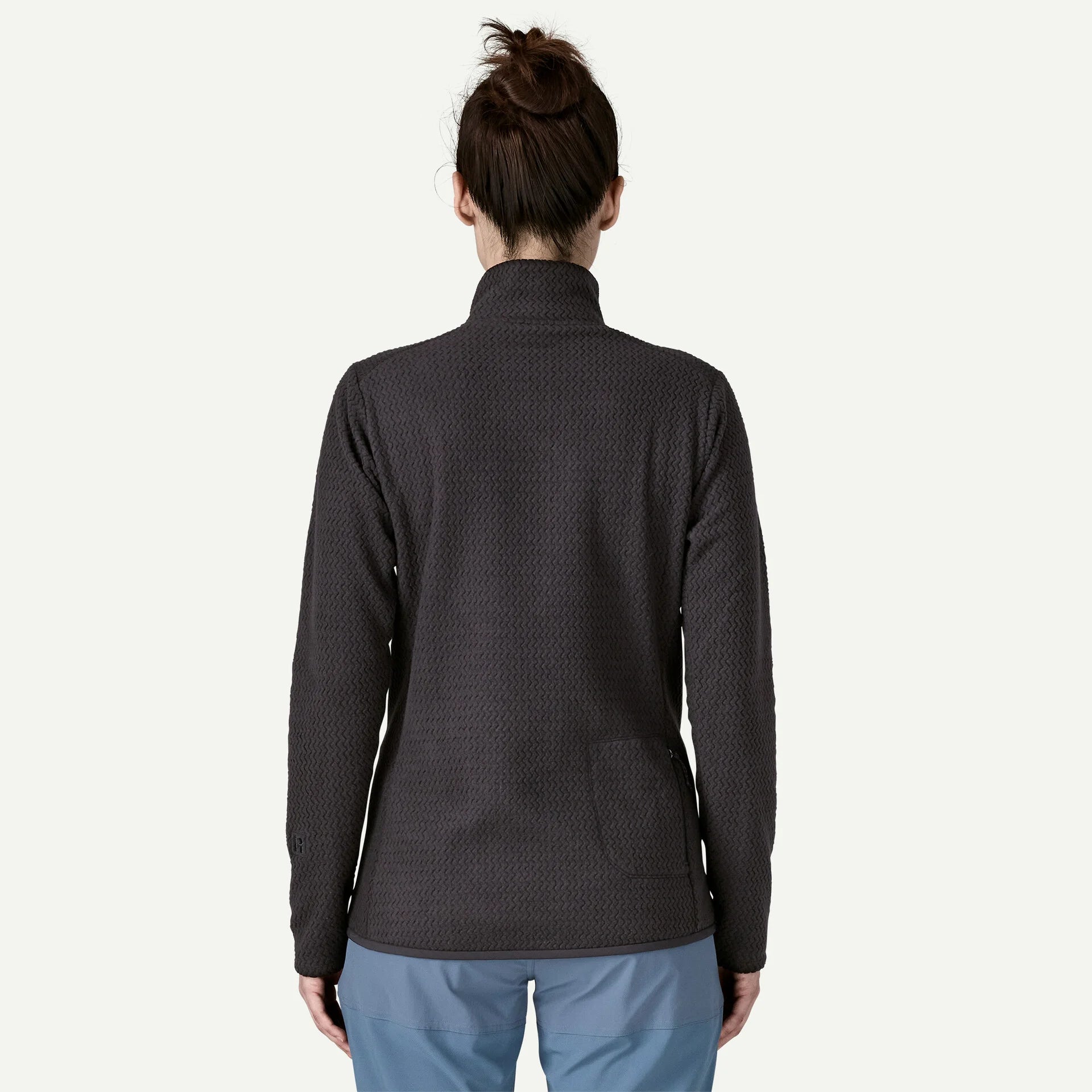 Person wearing a dark gray textured jacket on a white background