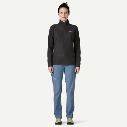 Woman wearing a black jacket and blue pants on a white background