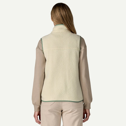Person wearing a beige fleece vest over a beige shirt on a white background