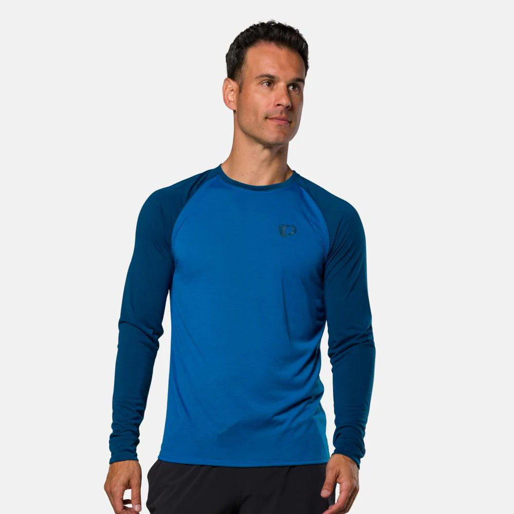 Man wearing a blue long-sleeve athletic shirt on a white background