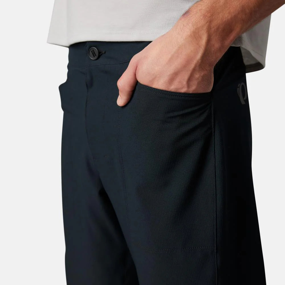 Person wearing navy pants with a white shirt on a light gray background