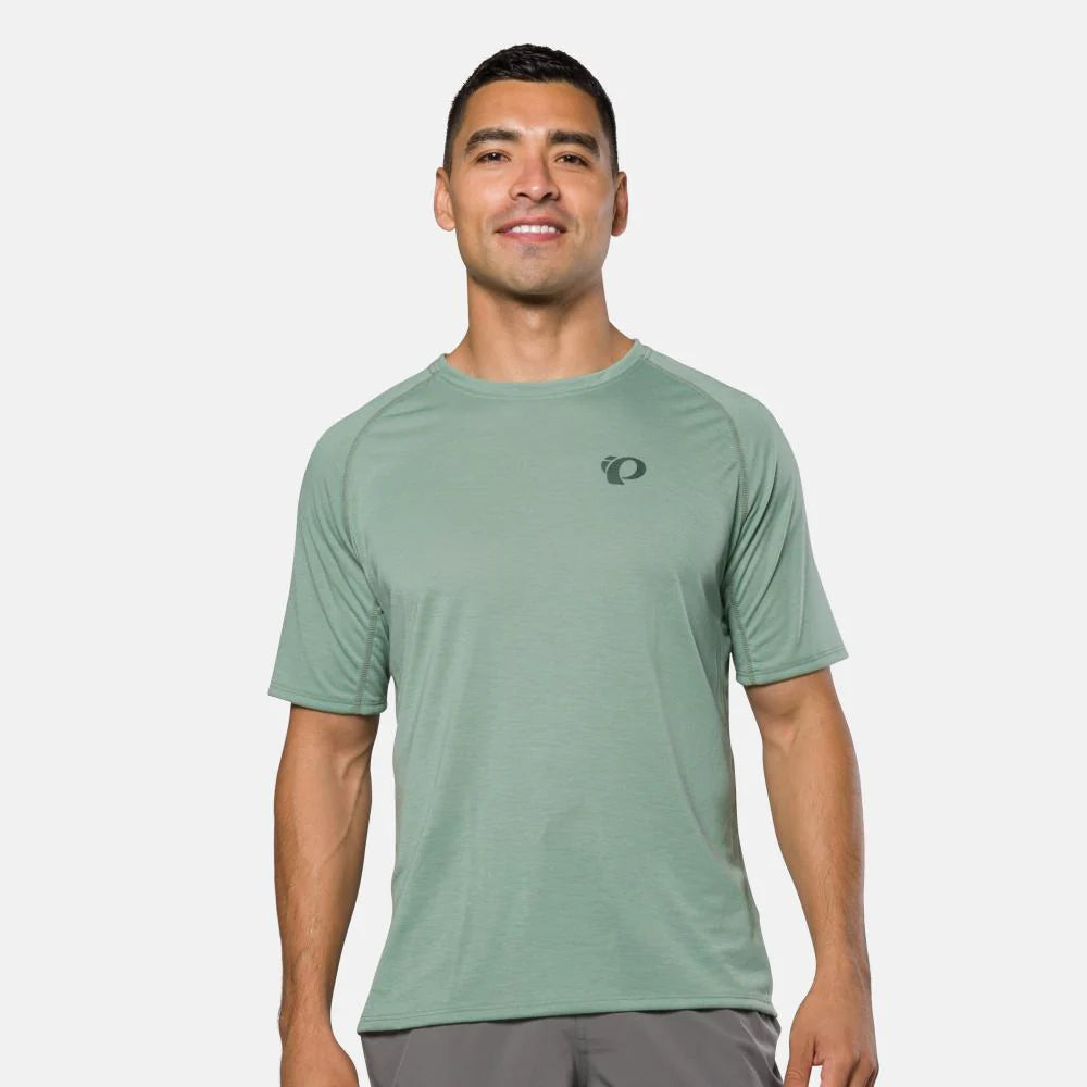 Man wearing a green athletic shirt with a logo on a white background