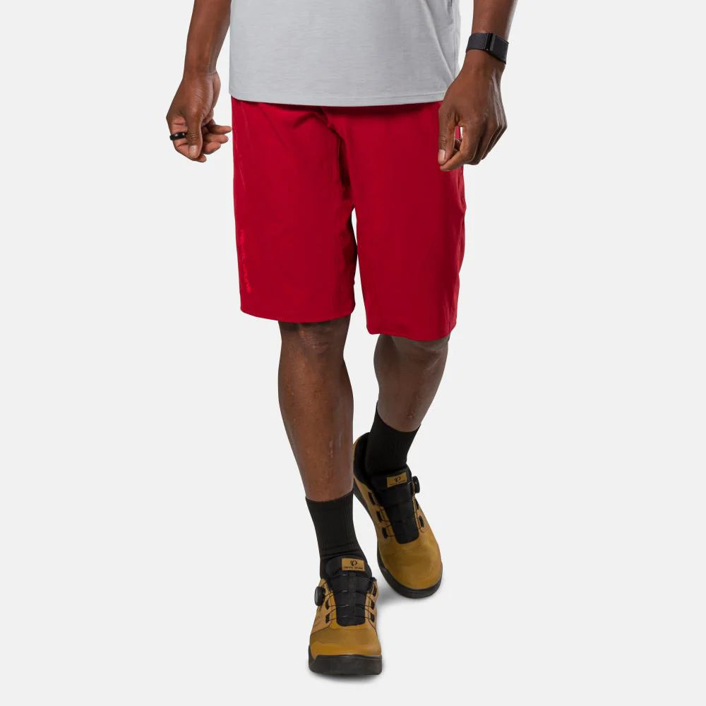 Person wearing red shorts and brown shoes on a white background