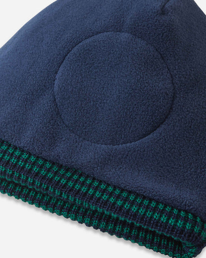 Navy blue beanie with green trim on a white background