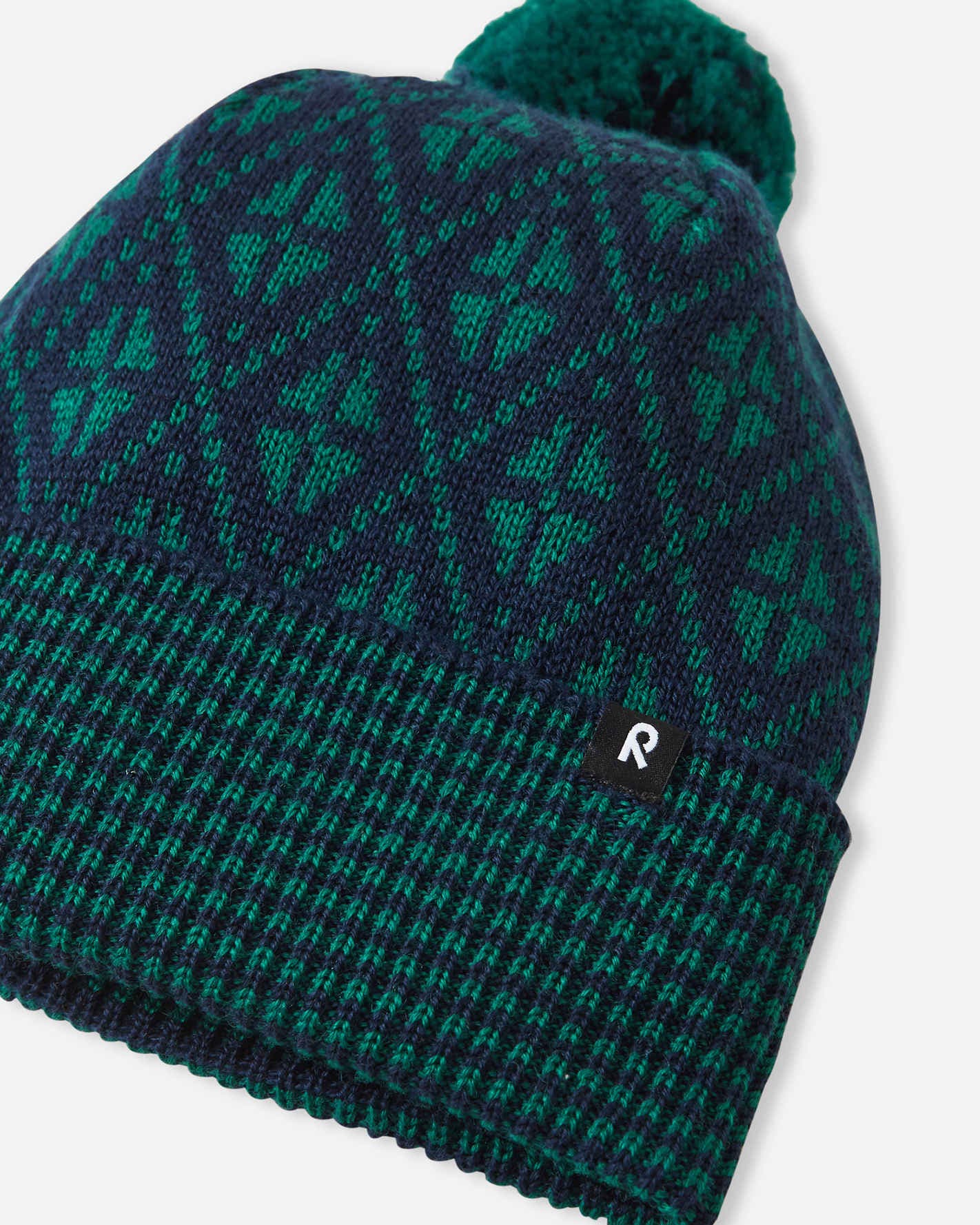 Green patterned beanie with pom-pom on a white background