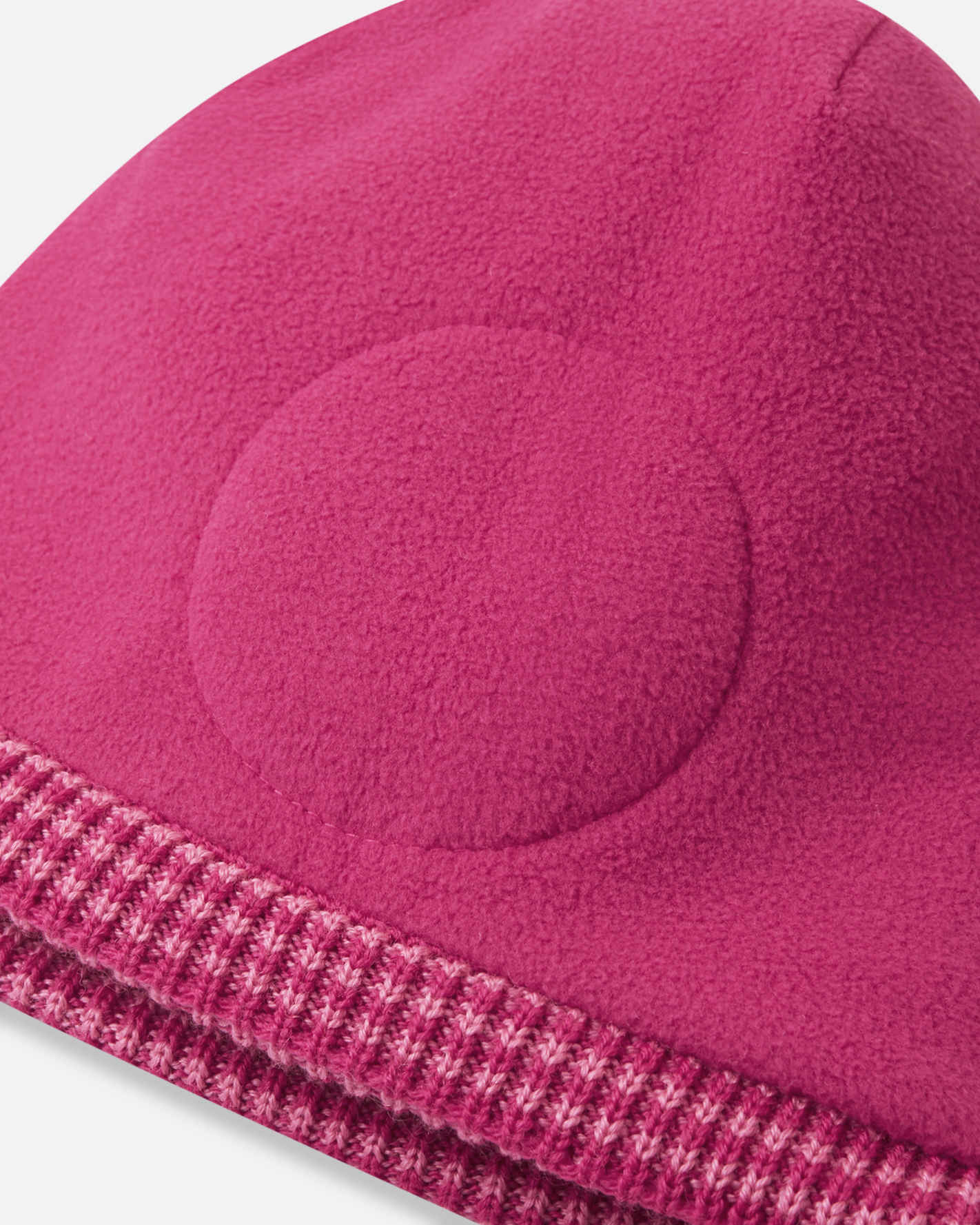 Close-up of a pink fleece beanie with a textured edge on a white background
