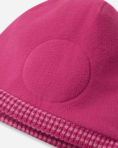 Close-up of a pink fleece beanie with a textured edge on a white background