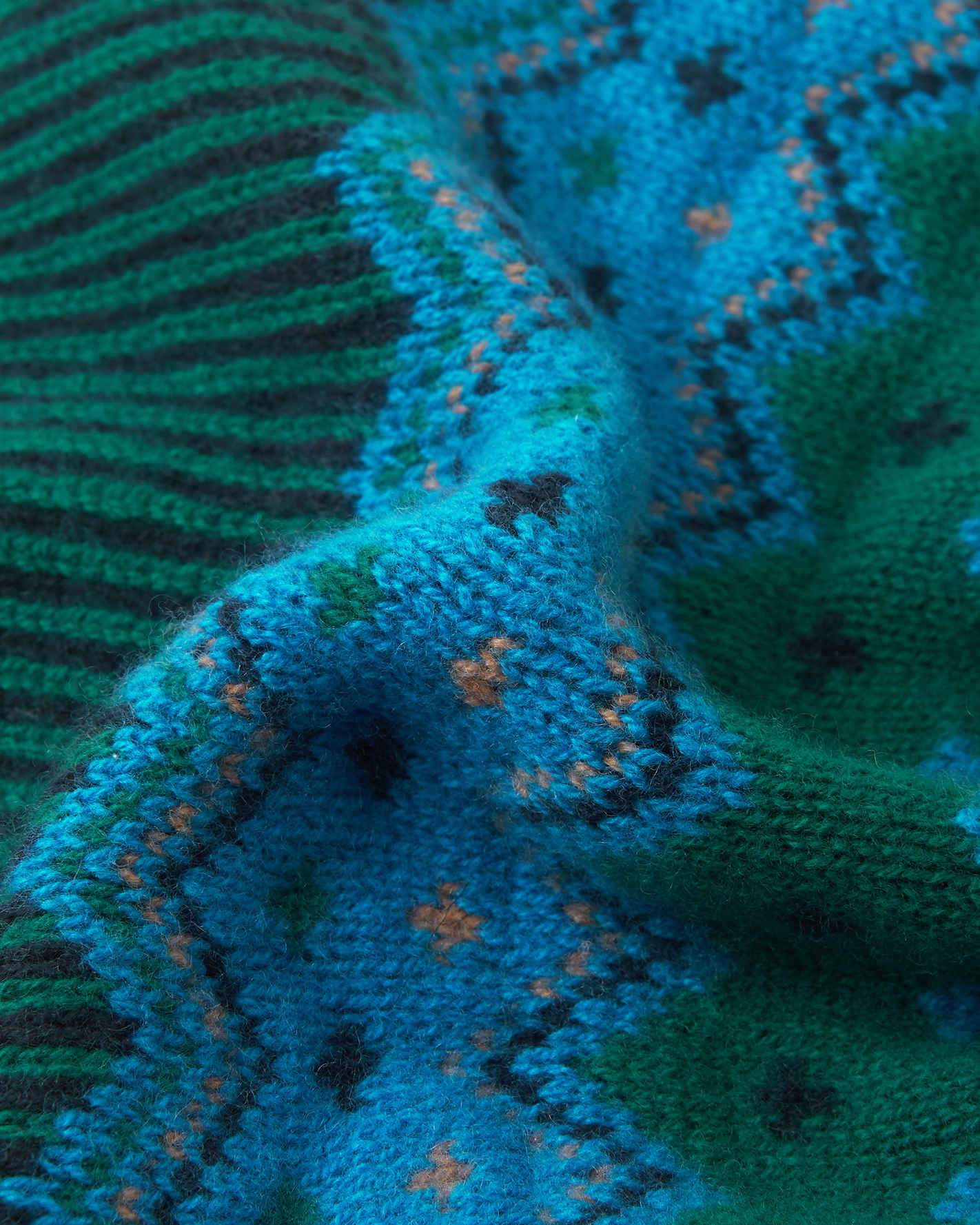 Close-up of a knitted fabric with blue, green, and black pattern