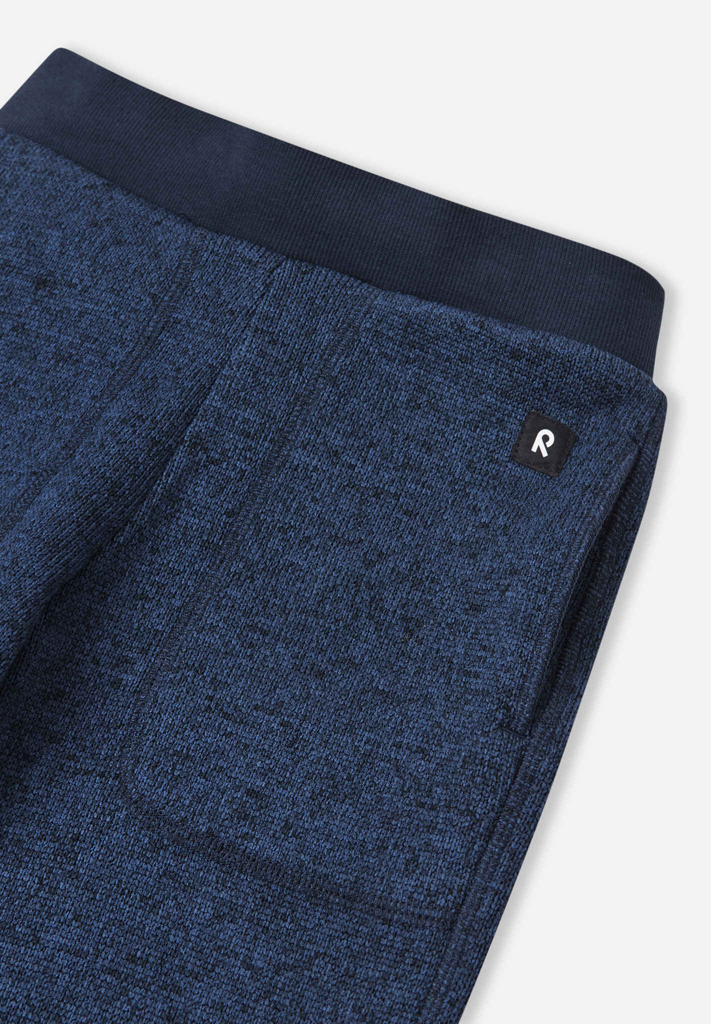 Close-up of blue fleece pants with a brand logo on a white background