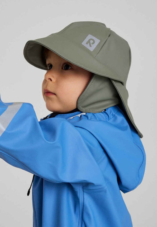 Child wearing a blue jacket and green hat with a logo on a plain background