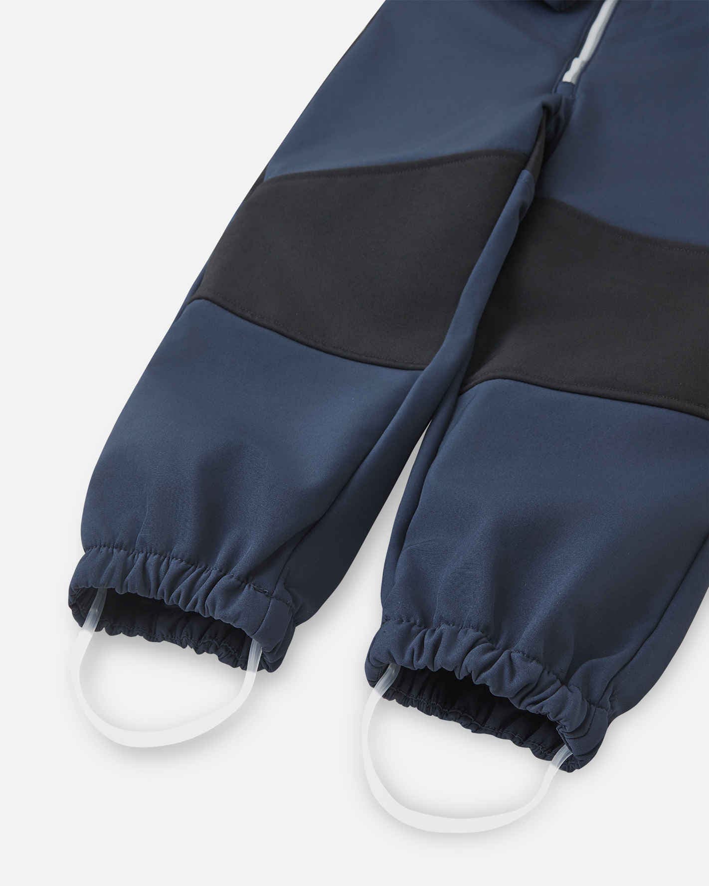 Navy blue rain pants with white soles on a light gray background