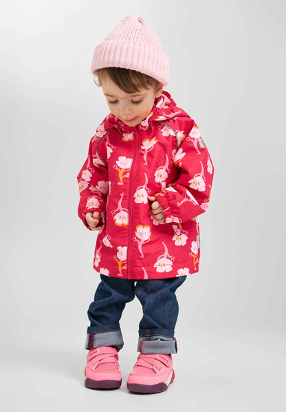 Child wearing a red floral coat, pink boots, and a pink hat on a light gray background