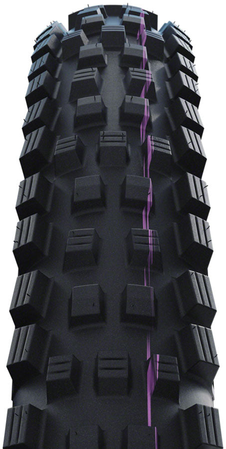 Close-up of a black off-road tire with prominent tread pattern on a white background