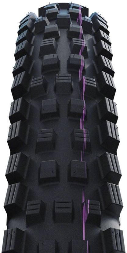 Close-up of a black off-road tire with prominent tread pattern on a white background