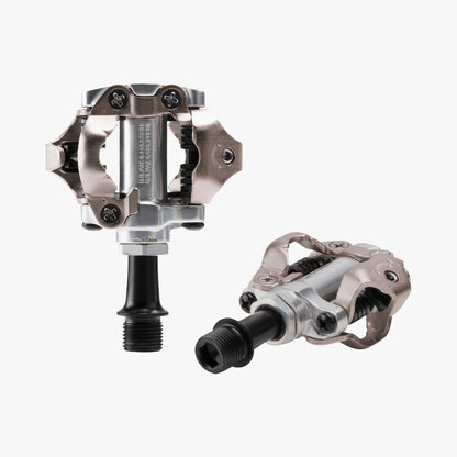Pair of metallic bicycle pedals on a white background