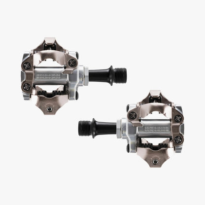 Pair of metallic bicycle pedals on a white background