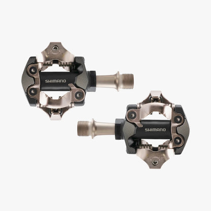 Two Shimano bicycle pedals on a white background