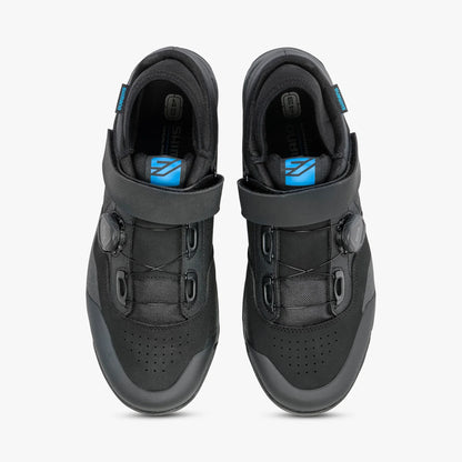 Black athletic shoes with blue accents on a white background