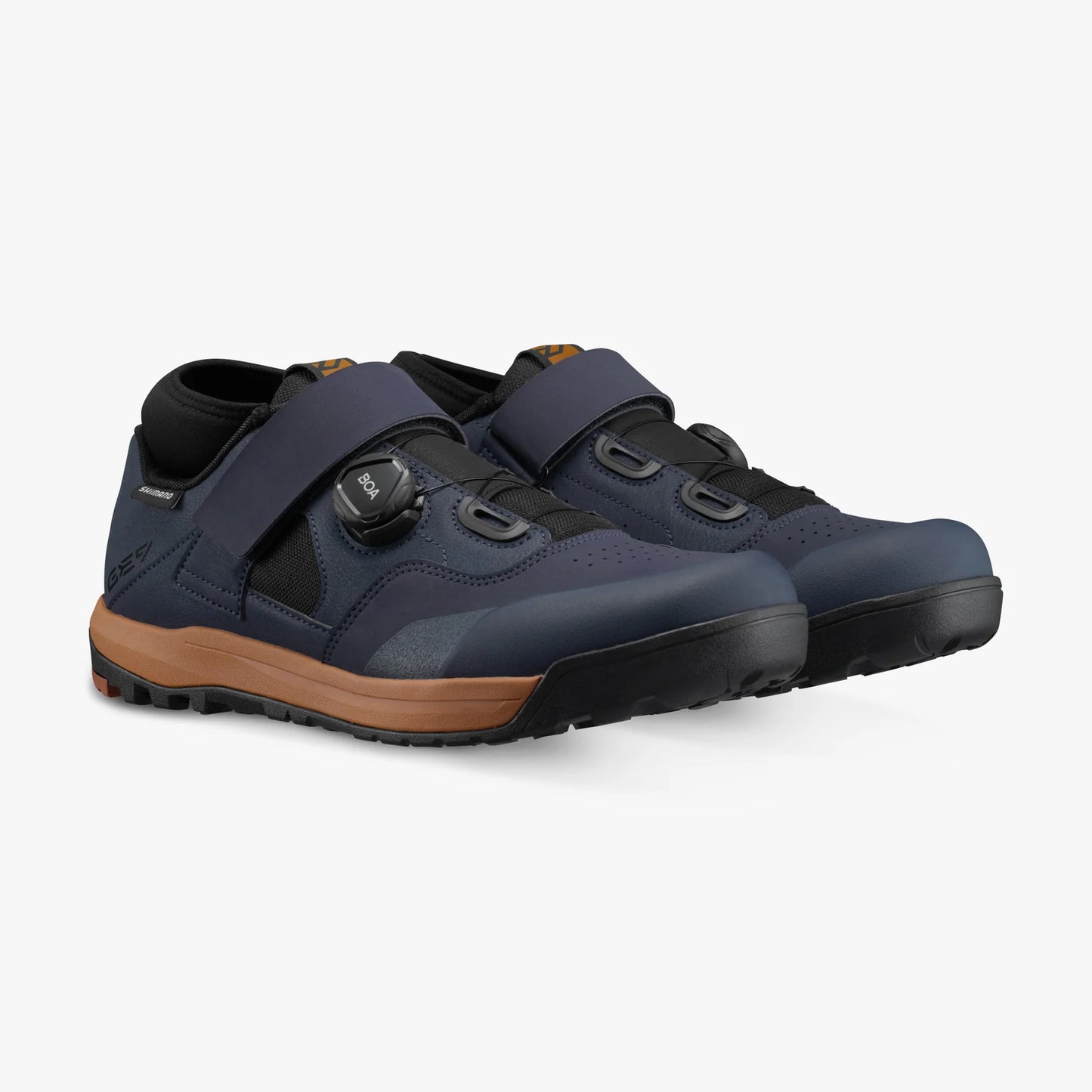 Pair of navy blue shoes with brown soles on a white background
