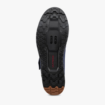 Close-up of a black shoe sole with a brand logo on a white background