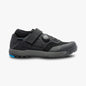 Black athletic shoe with a blue sole on a white background
