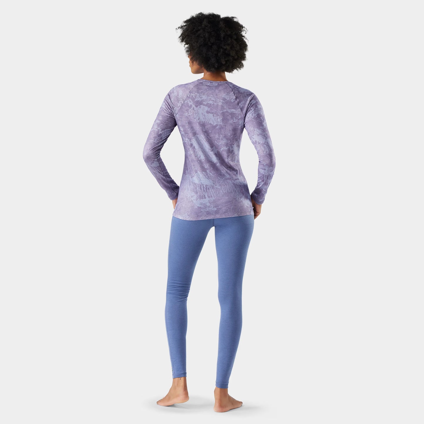 Person wearing a purple long-sleeve top and leggings on a white background
