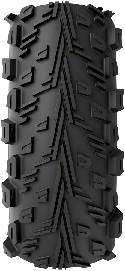 Black off-road tire with prominent tread pattern on a white background
